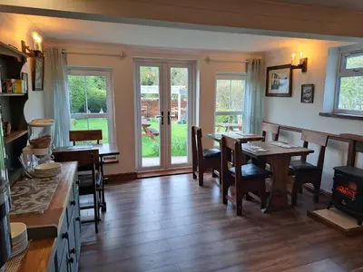a dining room with a table and chairs and windows at Llew Coch B&B formerly The Red Lion inn in Llanfihangel-nant-Melan