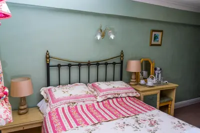 a bedroom with a bed and two tables with lamps at Llew Coch B&B formerly The Red Lion inn in Llanfihangel-nant-Melan