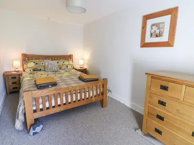 a bedroom with a wooden bed and a dresser at Pengraig in Tregaron