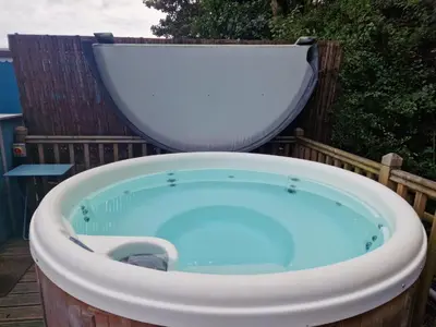 a bath tub with a toilet sitting on top of it at Glan yr Afon Dau - Relax Recuperate Hot Tub in Welshpool