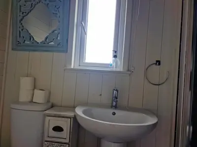 a bathroom with a sink and a window and a toilet at Glan yr Afon Un - Relax Recuperate Enjoy in Welshpool