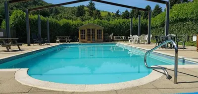 a large swimming pool with chairs and a table at Glan yr Afon Un - Relax Recuperate Enjoy in Welshpool