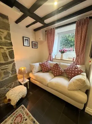 a living room with a couch and a window at Love Lane Cottage Dolgellau in Dolgellau