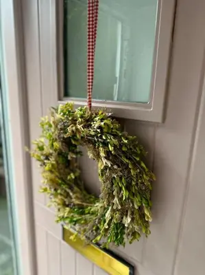 a wreath is hanging on a wall next to a window at Love Lane Cottage Dolgellau in Dolgellau