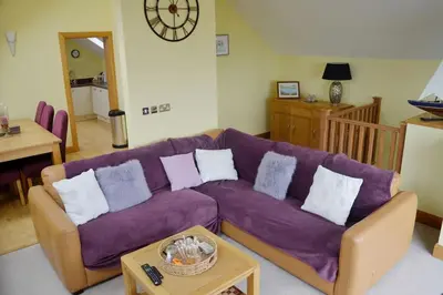 a living room with a purple couch and a table at Ruby's Watch in Barmouth
