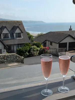 two glasses of wine sitting on a table at Ruby's Watch in Barmouth