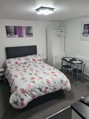a bedroom with a bed and a table in it at Cosy Studio - Town centre flat with free nearby parking in Shrewsbury