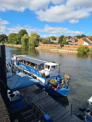 a boat is docked at a dock on a river at Cosy Studio - Town centre flat with free nearby parking in Shrewsbury