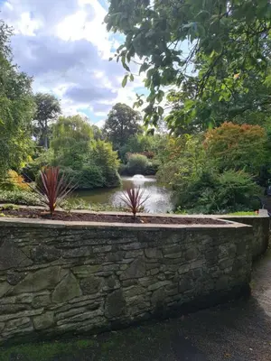a garden with a stone wall and a pond at Cosy Studio - Town centre flat with free nearby parking in Shrewsbury