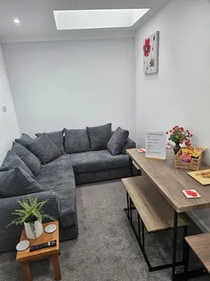 a living room with a couch and a table at Cosy Corner - Town centre flat with free nearby parking in Shrewsbury