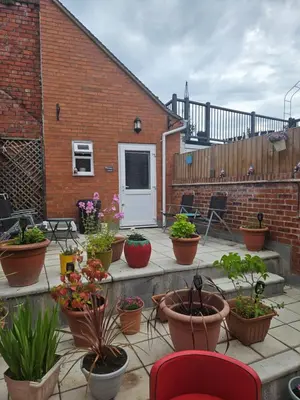 a patio with potted plants inront of a brick building at Cosy Corner - Town centre flat with free nearby parking in Shrewsbury