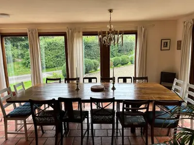 a dining room with a large wooden table and chairs at Happy Horse Cottages in Sennybridge
