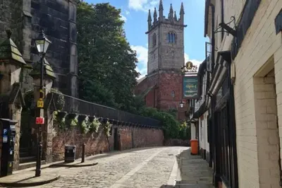 an empty street with a clock tower and a building at Cosy Nook - Town centre flat with free nearby parking, in Shrewsbury