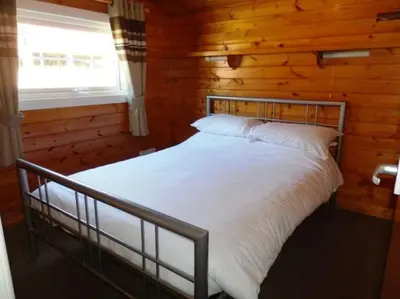 a bedroom with a bed in a log cabin at Cosy log cabin in Snowdonia 357 in Trawsfynydd