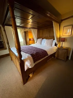 a bedroom with a large wooden bed in a room at The Harp Inn in Old Radnor