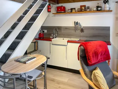 a kitchen with a table and a sink and a staircase at The Hideaway in Tregaron