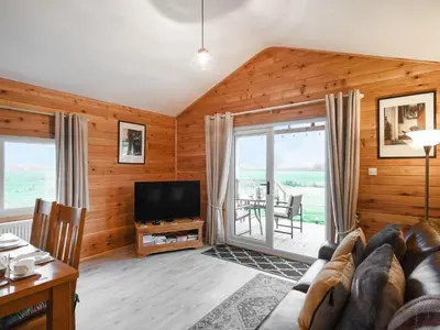 a living room with a couch and a television at Llwynog Lodge in Montgomery