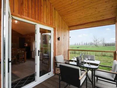 a screened in porch with a table and chairs at Llwynog Lodge in Montgomery