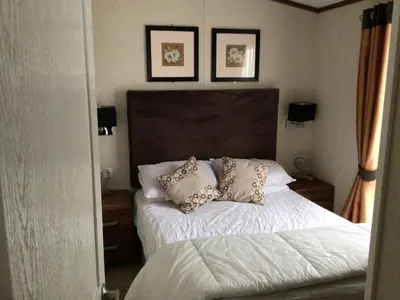 a bedroom with a bed with two pillows on it at Newquay Haven caravan 42x14 with Ocean Views in New Quay