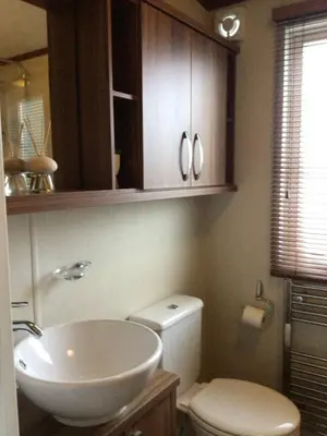 a bathroom with a white toilet and a sink at Newquay Haven caravan 42x14 with Ocean Views in New Quay