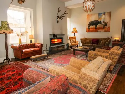 a living room with couches and a fireplace at Caynham Court in Ludlow