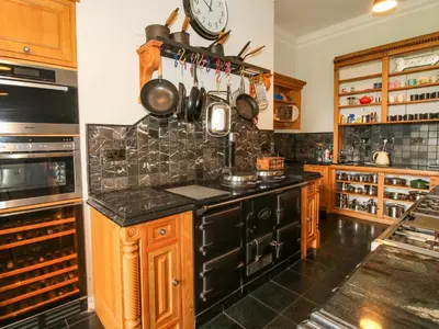 a kitchen with wooden cabinets and a black counter top at Caynham Court in Ludlow