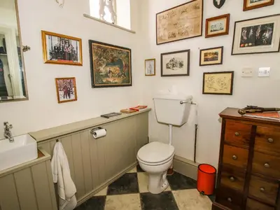 a bathroom with a toilet and pictures on the wall at Caynham Court in Ludlow
