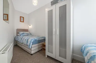 a small bedroom with a bed and a closet at 2 Bed Ground Floor Beach Location in Aberdyfi