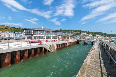 a bridge over a river next to a city at 2 Bed Ground Floor Beach Location in Aberdyfi