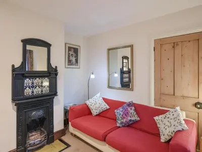 a living room with a red couch and a fireplace at Paul Pry in Ludlow