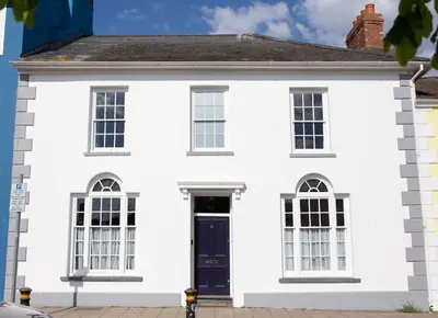 a white house with a blue door at Harbourside luxury house in Aberaeron