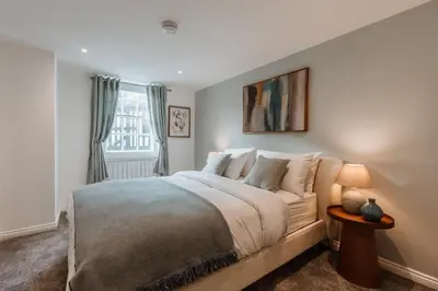 a bedroom with a large bed and a window at 2 Bed Apartment Overlooking the Square Step Out to Shops & Dining in Shrewsbury
