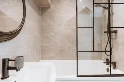 a shower with a glass door over a sink at 2 Bed Apartment Overlooking the Square Step Out to Shops & Dining in Shrewsbury