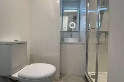a bathroom with a toilet and a sink and a shower at Barmouth beach ground level in Barmouth