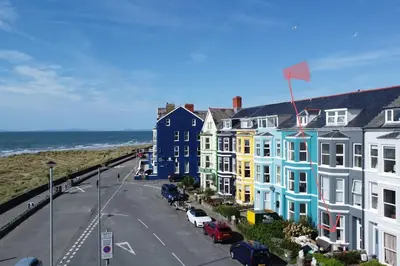 a row of colorful houses next to the ocean at Barmouth beach ground level in Barmouth