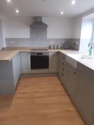 a kitchen with white cabinets and a black dishwasher at Jasmine Cottage in Shrewsbury