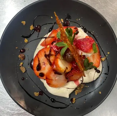 a dessert on a plate with strawberries and cream at Usk And Railway Inn in Sennybridge