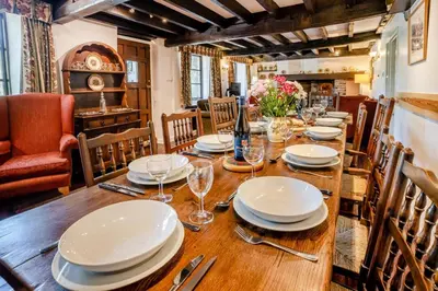 a dining room with a wooden table with plates and wine glasses at 7 Bed in Talgarth oc-h30349 in Talgarth