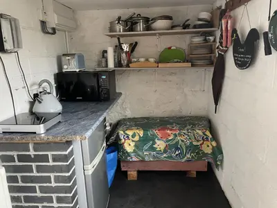 a small kitchen with a bench in the corner at Ty Hir at Blaenbrynich Farm in Brecon