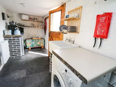 a kitchen with a washing machine and a sink at Ty Hir at Blaenbrynich Farm in Brecon