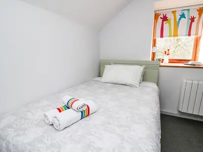 a small bedroom with a bed with two towels on it at Ty Hir at Blaenbrynich Farm in Brecon