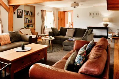 a living room with a couch and a table at Finest Retreats - The Welsh Farmhouse in Aberystwyth