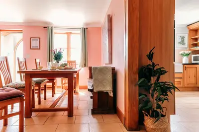 a dining room with a table and a plant at Finest Retreats - The Welsh Farmhouse in Aberystwyth