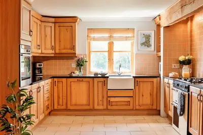 a kitchen with wooden cabinets and a window at Finest Retreats - The Welsh Farmhouse in Aberystwyth