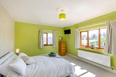a green bedroom with a bed and windows at 5 Bed in Pant-y-Dwr oc-w30200 in Pant-y-dwr