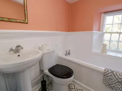a bathroom with a toilet and a sink and a tub at River Cottage in Llanbedr