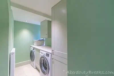 a laundry room with a washer and dryer at Seafront House in Aberdyfi