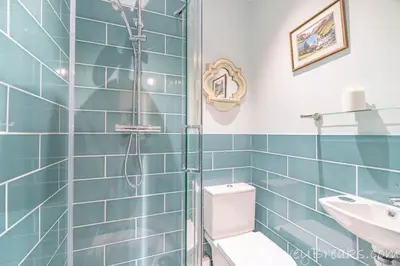 a bathroom with a shower and a toilet and a sink at Seafront House in Aberdyfi