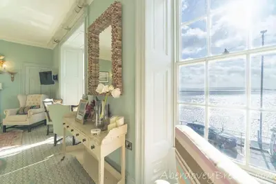 a room with a desk and a large window at Seafront House in Aberdyfi