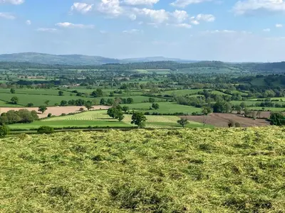 a view of a green field from a hill at Enchmarsh Farm Byre in Church Stretton